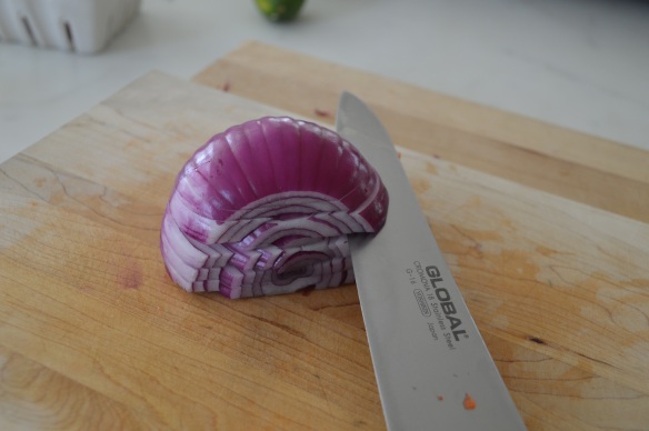 Cut onion in half lengthwise through the root. Cut off top and peel. Slice several layers almost all the way through to the root end.